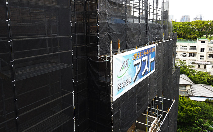 大規模修繕工事の現場（仮設足場と社名シート）